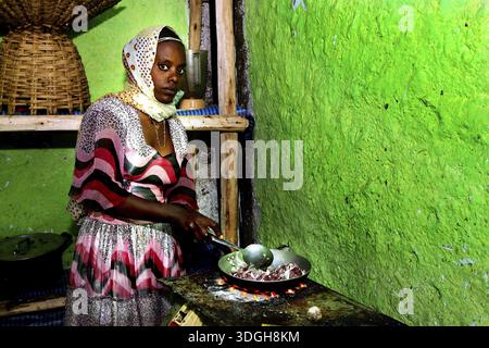 Une femme prépare des tibs dans une cuisine traditionnelle, Lalibela, Ethiopie Banque D'Images