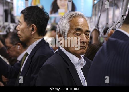 Les navetteurs empruntent un métro très fréquenté à Tokyo, Tokyo, Japon Banque D'Images