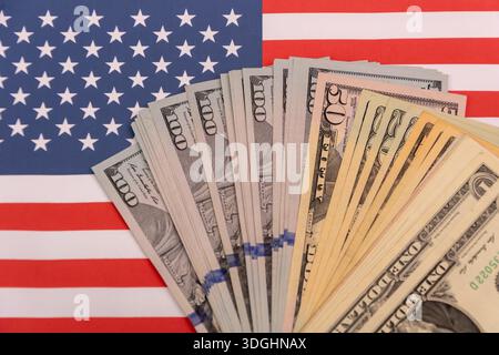 Billets en dollars des États-Unis étalés sur le drapeau américain. Banque D'Images