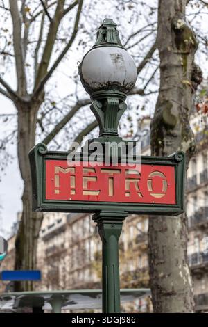 Une enseigne classique du métro parisien dans le style Val d'Osne, avec une lampe globe distinctive au sommet d'un poteau vert en fonte. Un concept de des urbains intemporels Banque D'Images