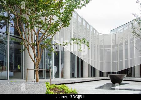 HANGZHOU, CHINE - 03 JUILLET 2017 : vue rapprochée d'un rideau ou d'un écran en maille perforée blanc utilisé comme élément architectural dans un jardin moderne. GRE Banque D'Images