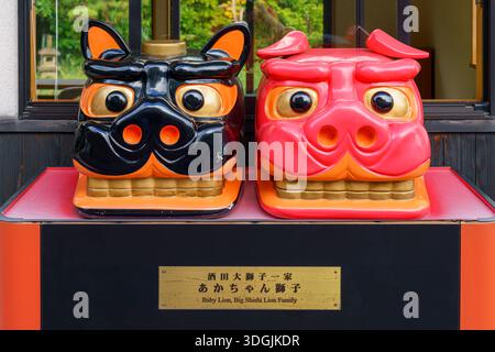 Sakata, Yamagata, Japon - 5 octobre 2024, vue rapprochée de sculptures de deux têtes de lion, rouge et noire, bébé Lion, et Big Shishi Lion Family, situé à nea Banque D'Images