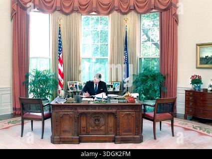 Président américain Ronald Reagan travaillant à son bureau, White House Oval Office, Washington, D.C. (États-Unis), Président Ronald Reagan White House Photographic Office, 15 juillet 1988 Banque D'Images