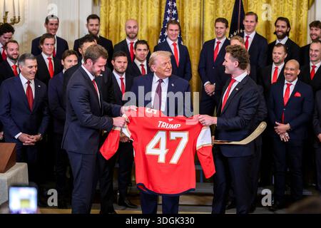 Washington, États-Unis d'Amérique. 15 janvier 2026. Le président américain Donald Trump, au centre, tient un maillot et un bâton de hockey en or, alors qu'il pose avec Matthew Tkachuk, à droite, et le capitaine de l'équipe Aleksander Barkov, à gauche, lors d'un événement célébrant le champion de la Coupe Stanley 2025, Florida Panthers, à la salle est de la Maison Blanche, le 15 janvier 2026, à Washington, DC crédit : Molly Riley/White House photo/Alamy Live News Banque D'Images