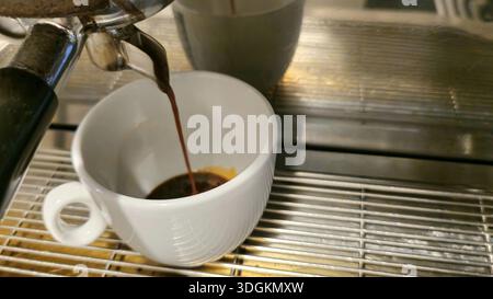 Espresso fraîchement préparé versé dans une tasse blanche Banque D'Images