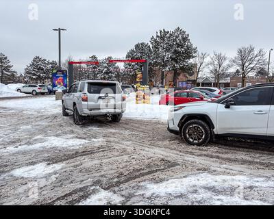 Les voitures s'alignent sur une voie enneigée du drive-in d'un restaurant McDonald's. Banque D'Images