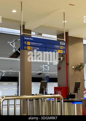 Johor, Malaisie, 14 janvier 2026 : vue dégagée des portes d'entrée et signalisation bilingue à la gare de Kempas Baru. Banque D'Images