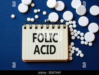 Symbole d'acide folique. Mot concept acide folique sur ordinateur portable. Beau fond bleu profond avec des pilules. Médecine et concept d'acide folique. Copier l'espace Banque D'Images