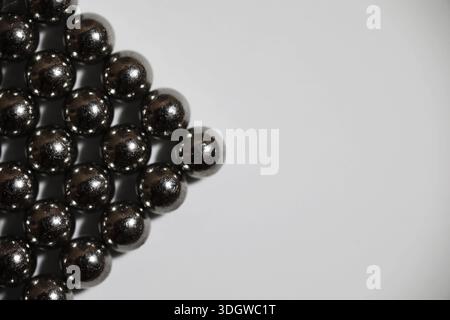 Boules métalliques gros plan. Billes de néodyme (aimants). Carrelage à roulement à billes magnétiques en grille hexagonale parfaite Banque D'Images