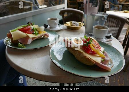 Table ronde avec deux tasses de café et deux sandwichs sains. Banque D'Images