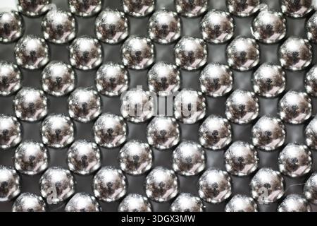 Boules métalliques gros plan. Billes de néodyme (aimants). Carrelage à roulement à billes magnétiques en grille hexagonale parfaite Banque D'Images