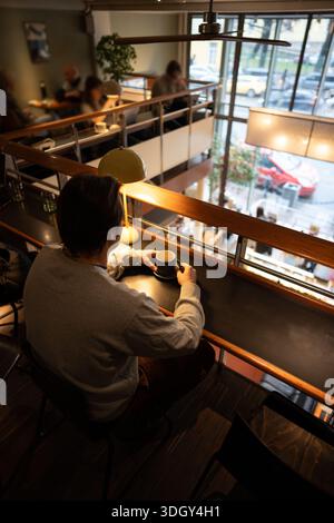 Homme détendu booklover se relaxant dans l'espace café co-working de librairie moderne après le shopping. Banque D'Images