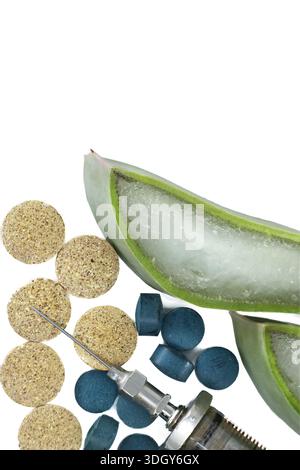 Une vue rapprochée d’une tranche de feuille d’aloe vera fraîche entourée de pilules à base de plantes et d’une seringue médicale, suggérant des remèdes naturels et un applicat thérapeutique Banque D'Images