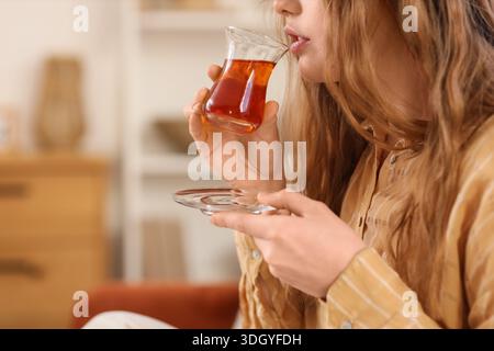 Belle jeune femme buvant du thé turc à la maison Banque D'Images