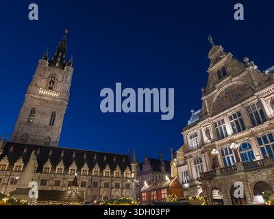Le beffroi de Gand brille de chaudes lumières de Noël au cours d'une paisible soirée d'hiver, mettant en valeur l'architecture historique, le charme des vacances et une saison magique Banque D'Images