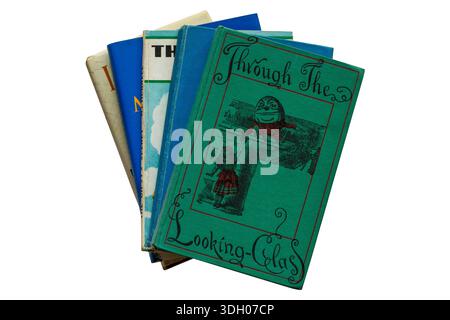 Sélection de livres à dos rigide avec livre Childs 1952 vieux vintage à travers le livre Looking Glass par Lewis Carroll sur le dessus isolé sur fond blanc Banque D'Images