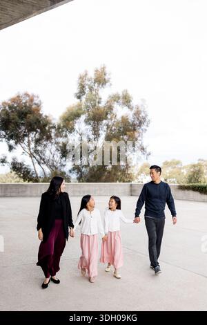 Famille asiatique de quatre marchant sur le campus de l'UCSD à San Diego Banque D'Images