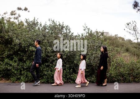 Famille asiatique de quatre marchant sur le campus de l'UCSD à San Diego Banque D'Images