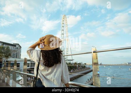 Femme profitant du front de mer de Dubaï avec vue sur l'emblématique roue d'observation Ain Dubaï en arrière-plan, touriste à Dubaï Banque D'Images