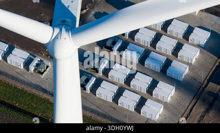 Vue aérienne d'une éolienne blanche dure debout à côté de rangées de conteneurs blancs soigneusement disposés, créant un contraste géométrique, Eemshaven, Net Banque D'Images