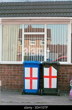 Les poubelles en plastique de Boston, Lincolnshire, arborant la croix de Saint George (drapeau anglais), ont mis en évidence l'intersection de l'identité nationale et de l'environnement urbain banal. Boston est statistiquement connue pour son pourcentage élevé de résidents d'Europe de l'est, et de tels affichages reflètent le sentiment local concernant le patriotisme et la fierté de la communauté. La scène met en lumière le paysage visuel d'une ville souvent citée dans les discussions sur le Brexit, la migration et l'identité culturelle dans l'Angleterre rurale. Banque D'Images