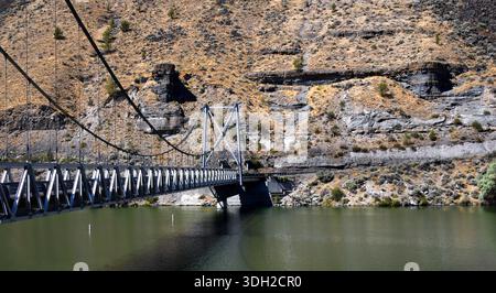 Un pont suspendu à une voie enjambe la rivière Deschutes dans le parc d'État de Palisades, dans le centre de l'Oregon. Banque D'Images