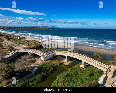 Vue aérienne d'un pont sur l'embouchure d'une rivière rencontrant la mer turquoise, avec une plage de sable sous un ciel lumineux, Chania, Chania, Grèce. Banque D'Images