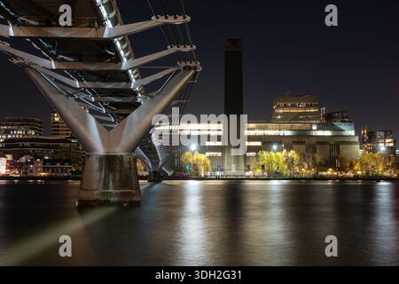 Le Millennium Bridge et la Tate Modern sont éclairés la nuit sur la Tamise, dans le centre de Londres. Banque D'Images