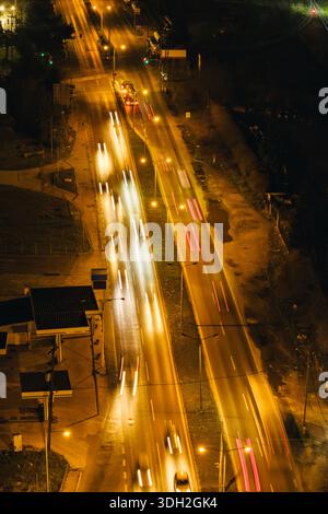Thessalonique, Grèce — vue aérienne de nuit d'une route à plusieurs voies très fréquentée dans les districts occidentaux, avec des pistes lumineuses de véhicules et infrastruc illuminé Banque D'Images