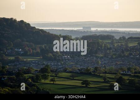 La lumière du soir brille sur la ville de Cam et Stinchcombe Hill sur le Cotswold Edge, avec l'estuaire de Severn derrière. Banque D'Images