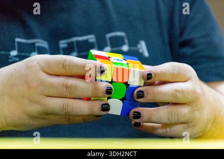 Mains résolvant Rubik’s Cube lors d’une compétition de speedcubing, montrant l’habileté, la concentration et la résolution d’énigmes. Espagne. Banque D'Images