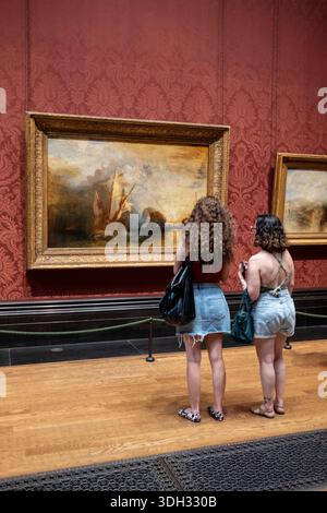 Jeunes femmes admirant les peintures de JMW Turner à la National Gallery Londres Angleterre Royaume-Uni Banque D'Images