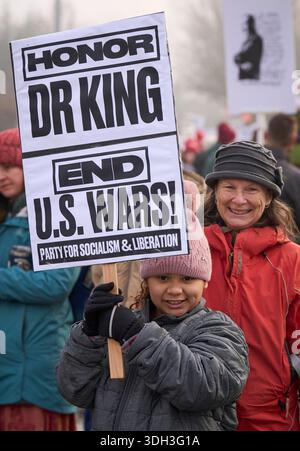 Une jeune fille tient une pancarte lors d'une marche commémorant l'anniversaire du révérend Martin Luther King à Eugene, Oregon, le 19 janvier 2026. Banque D'Images