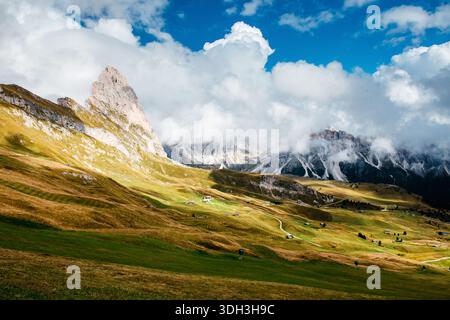 La ligne de crête emblématique de Seceda dans les Dolomites italiennes est baignée de soleil, contrastant avec des nuages spectaculaires et des paysages montagneux accidentés Banque D'Images