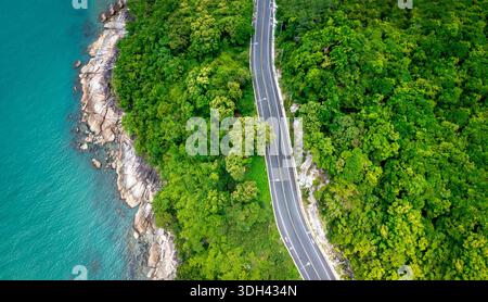 Vue aérienne de la route entre le cocotier et le grand océan en journée à Nakhon si Thammarat, Thaïlande Banque D'Images