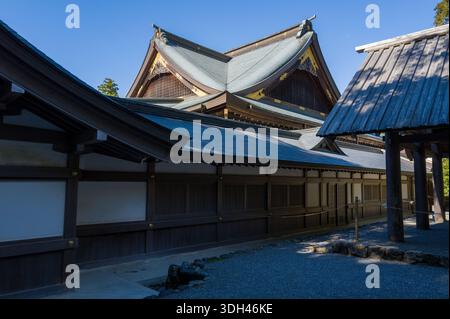 ISE, Japon - 29 octobre 2023 : le toit et le mur extérieur de la salle Kaguraden à ISE Jingu sont présentés avec une architecture traditionnelle en bois, des toits en tuiles inclinées et des éléments décoratifs dorés sous un ciel bleu clair. Banque D'Images