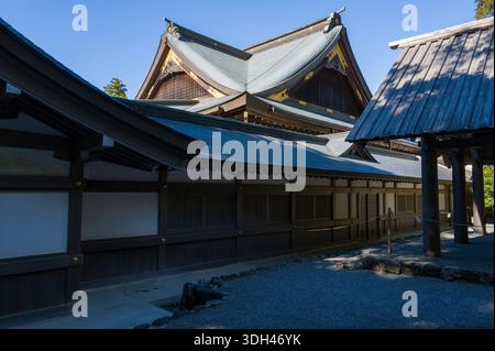 ISE, Japon - 29 octobre 2023 : L'extérieur de la salle Kaguraden à ISE Jingu est montré avec une architecture traditionnelle en bois, des toits en tuiles inclinées et des éléments décoratifs en or sous un ciel bleu clair. Banque D'Images