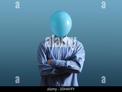 Homme portant une chemise bleue avec un ballon bleu clair couvrant sa tête, symbolisant l'anonymat et le manque d'identité Banque D'Images