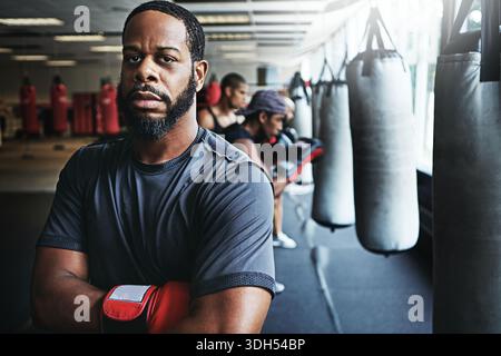 Portrait, boxeur et homme avec confiance dans le club pour le fitness, le sport ou entraîneur déterminé pour le combat. Entraîneur de boxe, athlète et personne sérieuse avec Banque D'Images