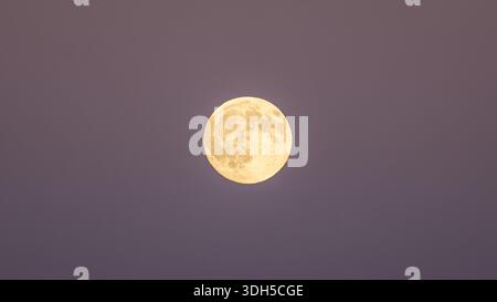 Une pleine lune se lève dans le ciel nocturne au-dessus des superbes Alpes françaises, projetant une lueur sereine sur fond de crépuscule, symbolisant la tranquillité et le nat Banque D'Images