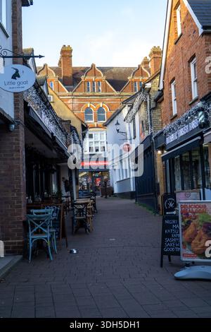 Une rue étroite à Saffron Walden, Essex, Royaume-Uni, bordée de boutiques et de sièges en plein air, décorée pour Noël Banque D'Images