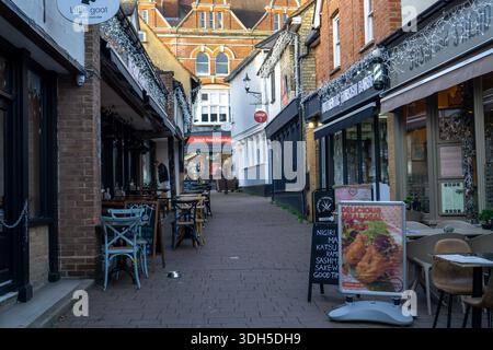 Une rue étroite à Saffron Walden bordée de boutiques et de restaurants, décorée de lumières scintillantes pour Noël Banque D'Images