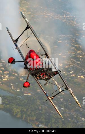 Cette photographie air-air représente un Pitts S-2S Prometheus N540S piloté par Skip Stewart effectuant des manœuvres acrobatiques lors d'une exposition de fumée à la Sun n Fun Aerospace Expo en Floride 2025. Le biplan présente un cockpit, un fuselage, des ailes, une queue, des hélices, et surfaces de contrôle. L'image démontre le vol en formation, les performances acrobatiques et les compétences du pilote dans un biplan monomoteur haute performance. Banque D'Images