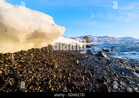 Neige fondante sur la plage de Breivikbotn surplombant le fjord, Troms og Finnmark, nord de la Norvège Banque D'Images