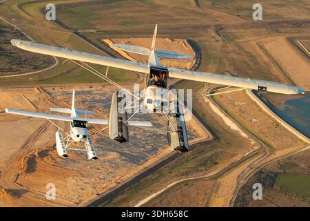 La photographie montre un Cessna 172S Skyhawk II N1430V et un Piper PA-18 Super Cub N6738C volant en formation avec des flotteurs pour les opérations nautiques lors d'une exposition air-air à la Sun n Fun Aerospace Expo en Floride 2025. Les deux avions sont des avions monomoteurs à pistons avec des ailes hautes, montrant le fuselage, les ailes, la queue, les hélices, et cockpits. L'image montre le vol en formation, la coordination des pilotes et la conduite des avions légers. Banque D'Images