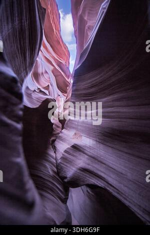 Des murs de grès lisses forment un couloir étroit à l'intérieur d'Antelope Canyon avec une lumière spectaculaire et des formes de roches coulantes Banque D'Images