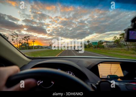 Les conducteurs voient de l'intérieur d'une voiture sur une route rurale avec des véhicules se déplaçant vers l'avant. Mouvement, navigation et concept de vie urbaine. Banque D'Images