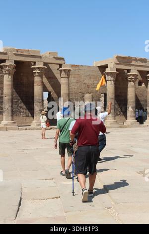 Assouan, Égypte - 20 octobre 2023 : guide touristique avec un drapeau et des touristes au Temple d'Isis Banque D'Images