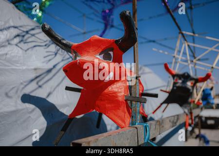 Plusieurs petites mâché têtes de taureau en papier rouge montées sur un cadre métallique lors des préparatifs pour un festival culturel traditionnel au Mexique. Banque D'Images