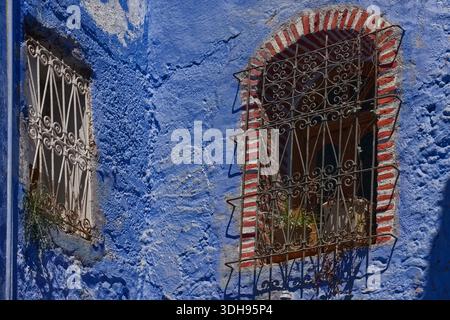 066 paire de fenêtres barrées placées à un angle de 90 degrés dans un coin à un élargissement d'une allée dans la médina, habituellement peintes en bleu. Chefchaouen-Maroc Banque D'Images